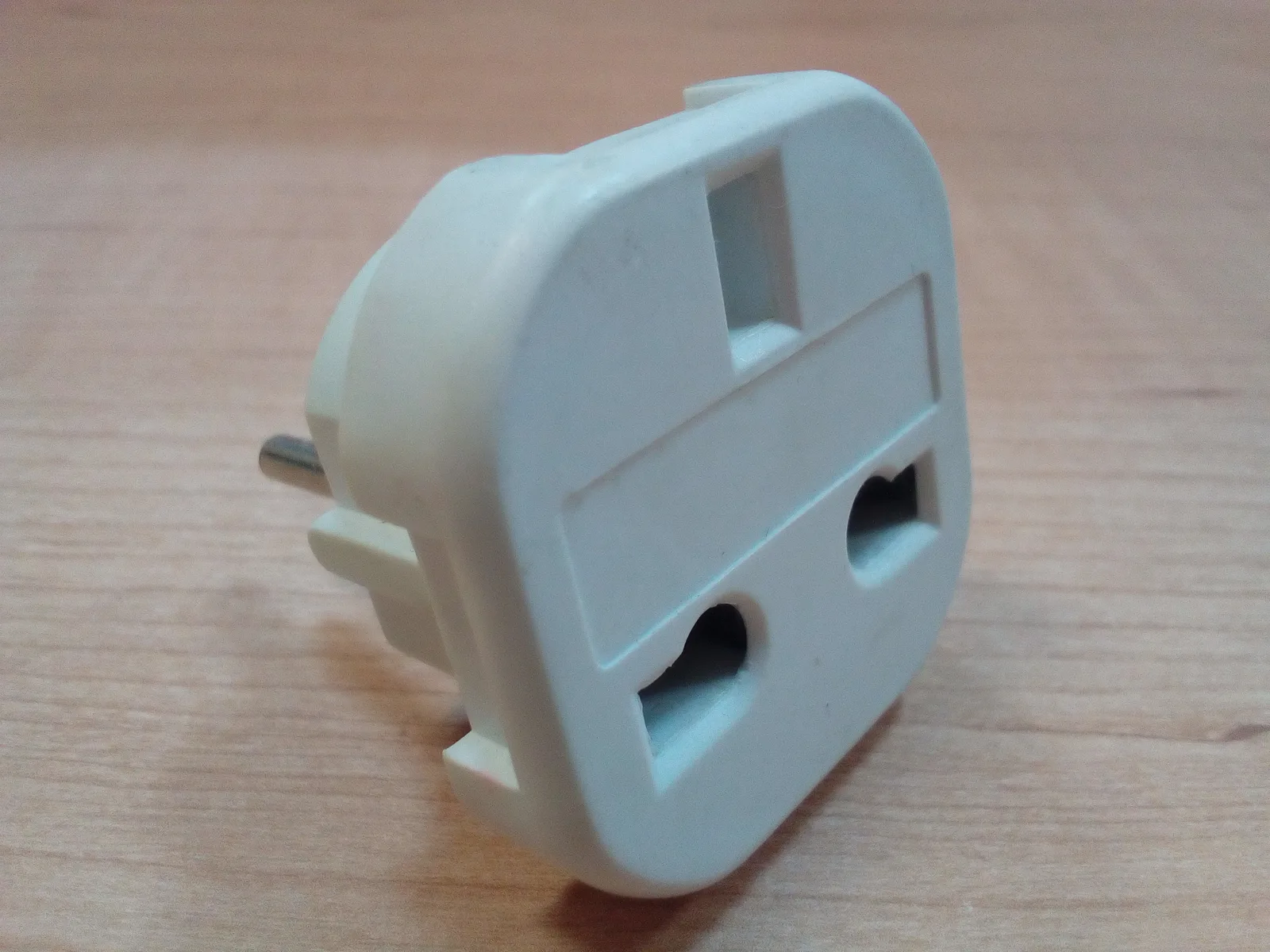 Travel adapter with a British Type G socket and European round pins