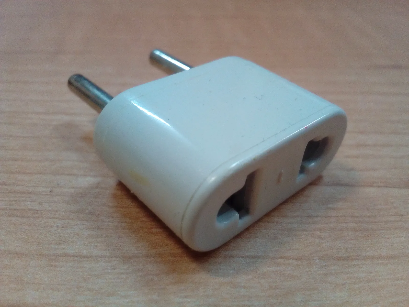Travel adapter accepting flat American pins and ending in European round pins