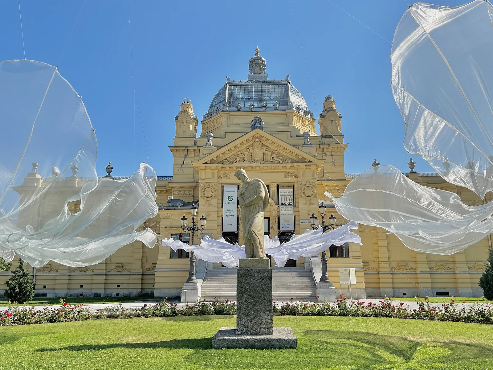 Yellow Art Pavilion in Zagreb seen across its lawn during a 2022 outdoor installation