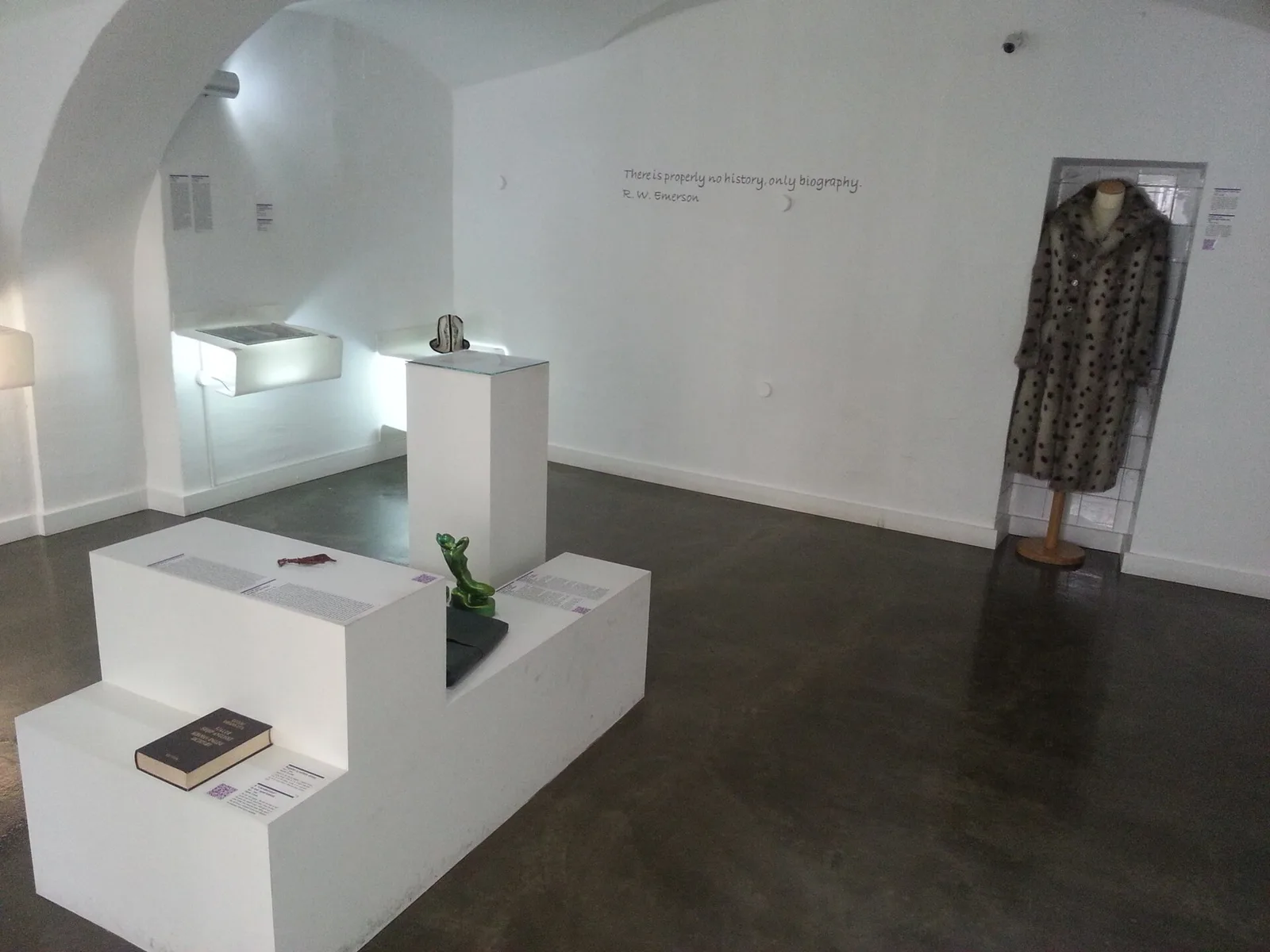 White gallery room with donated objects and story labels at the Museum of Broken Relationships