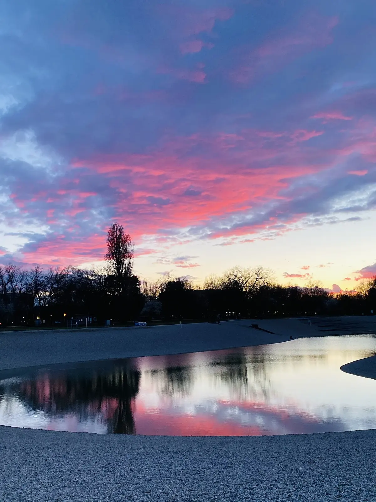 Bundek lake reflecting a vivid evening sky in Zagreb