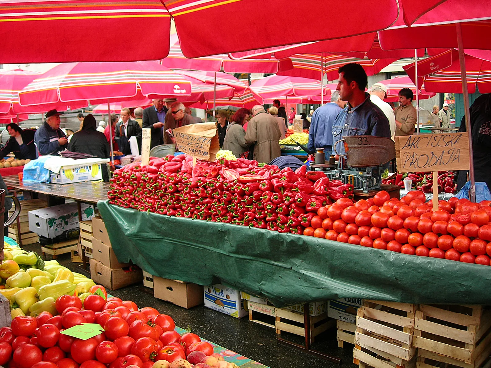 Fruit and vegetable stalls beneath red umbrellas at Dolac Market