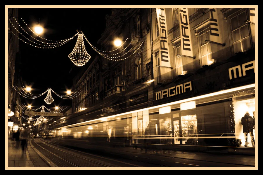 Ilica shopfronts and tram rails illuminated by decorative lights at night