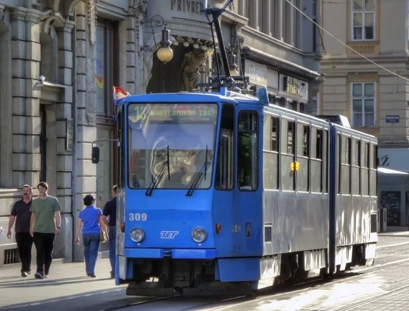 Blue ZET tram travelling along Ilica beside pedestrians and historic buildings