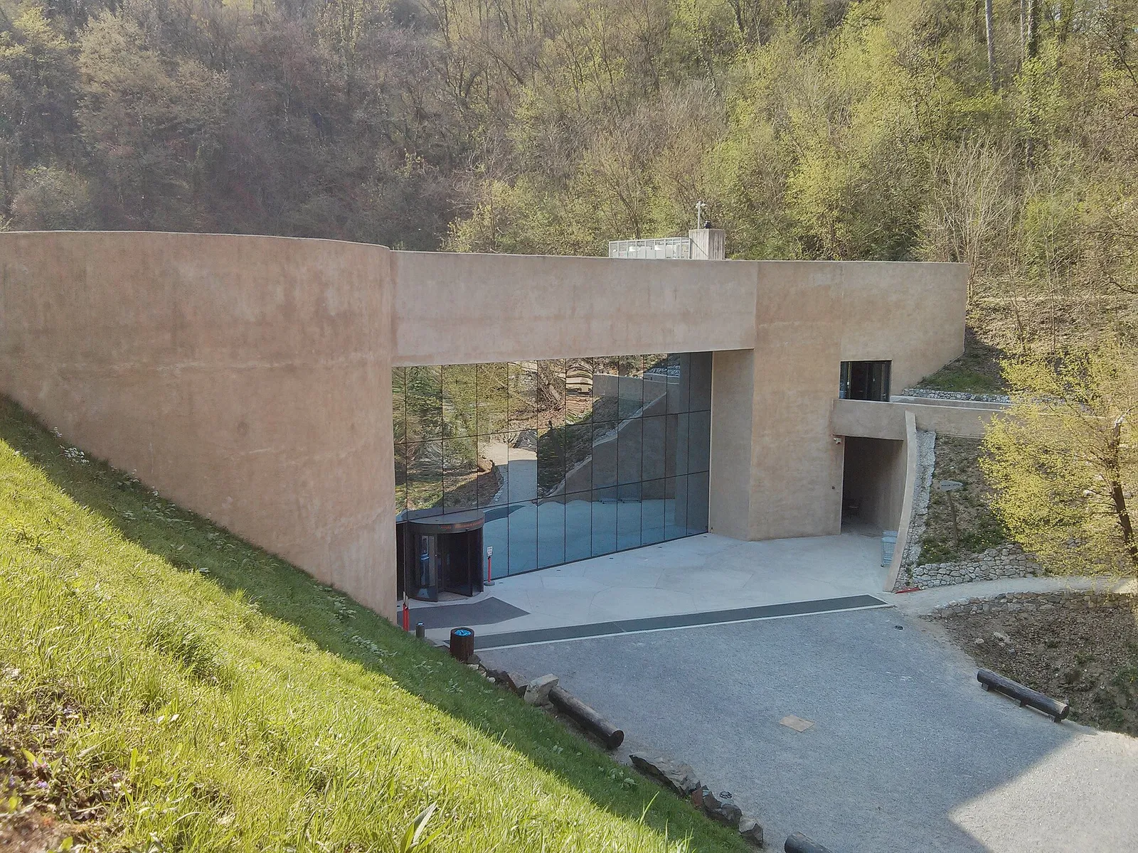 Krapina Neanderthal Museum embedded between grassy and wooded hills