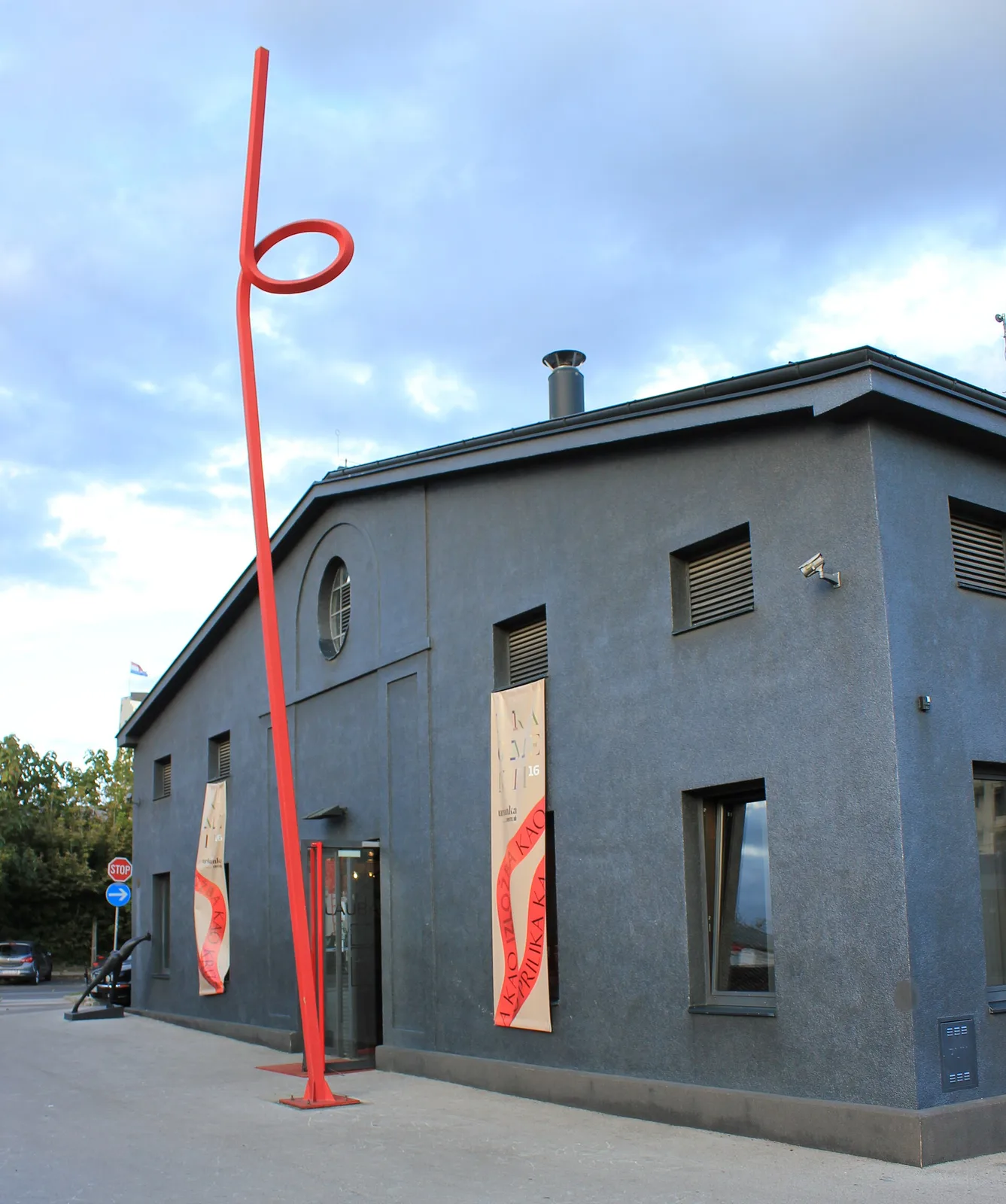 Grey industrial exterior and red sculpture at Lauba in Zagreb