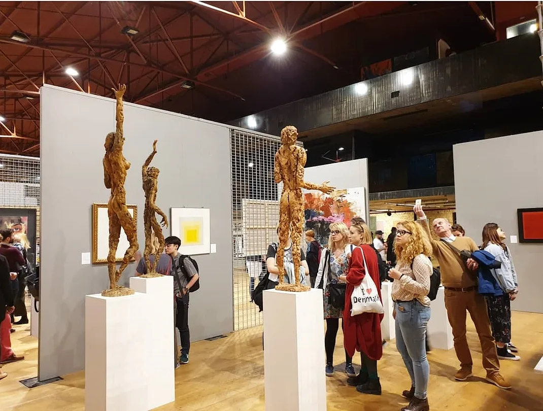 Visitors gathered around contemporary sculptures at an art fair inside Lauba