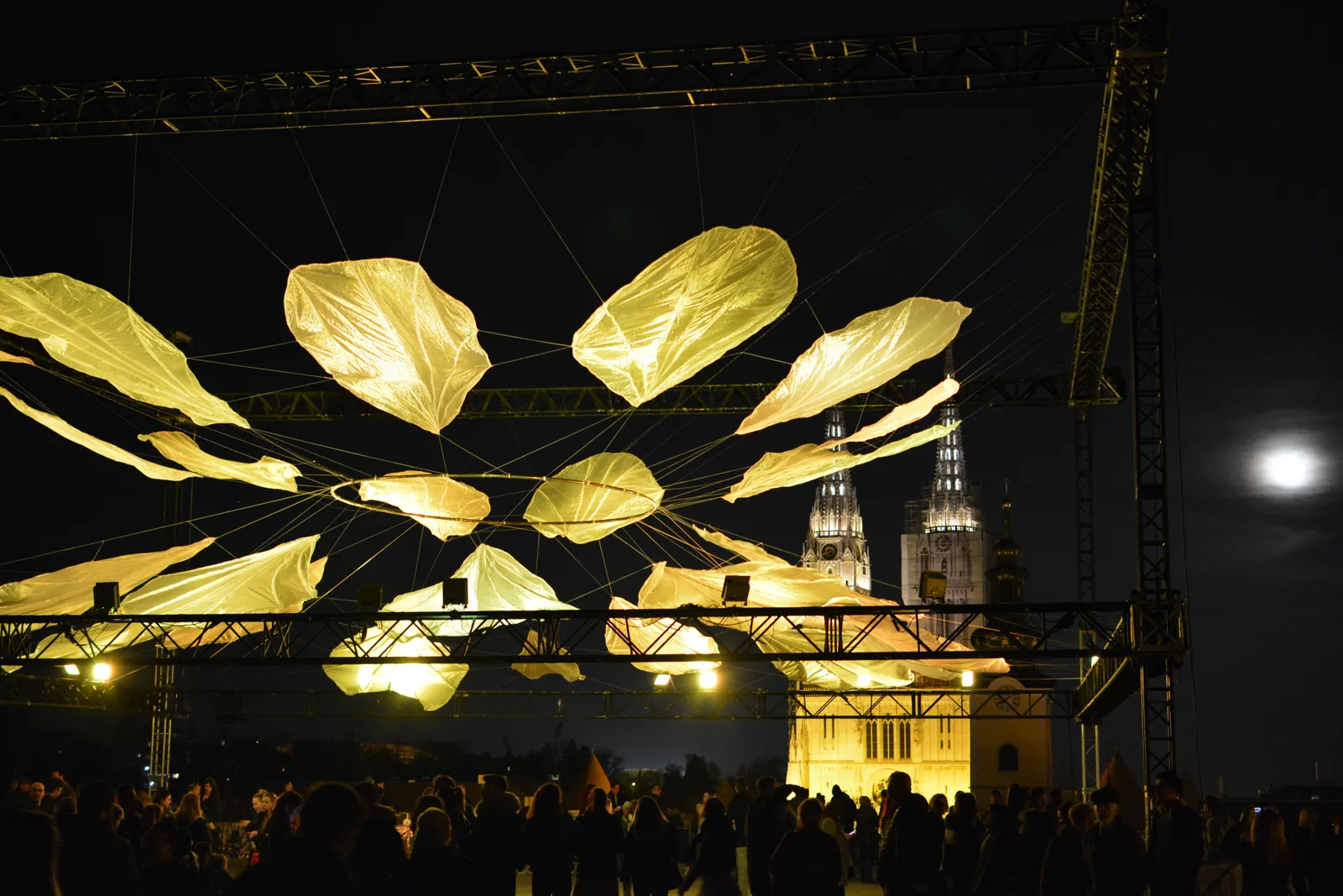 Golden illuminated leaves suspended above a night crowd at Zagreb's 2019 Festival of Lights