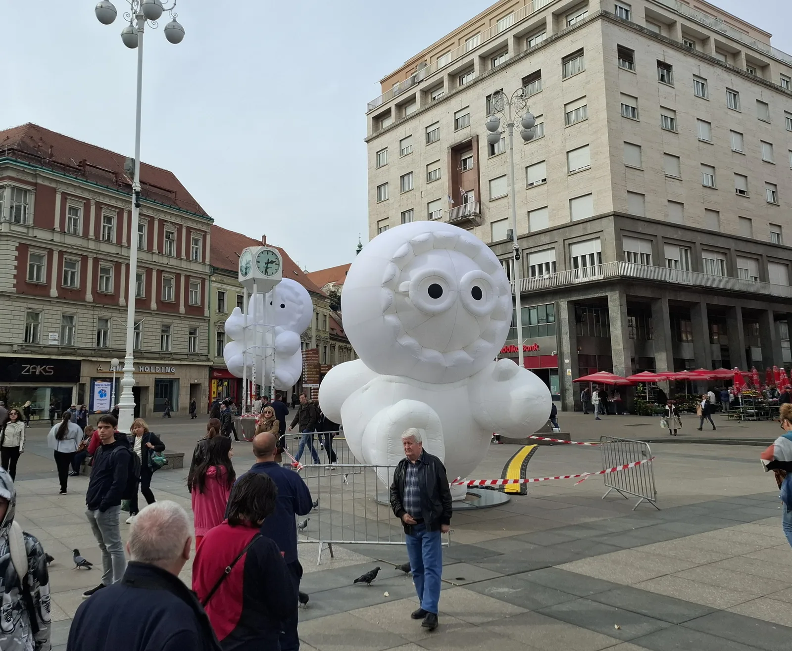 Large white Anooki figures installed around the clock on Ban Jelačić Square in 2025