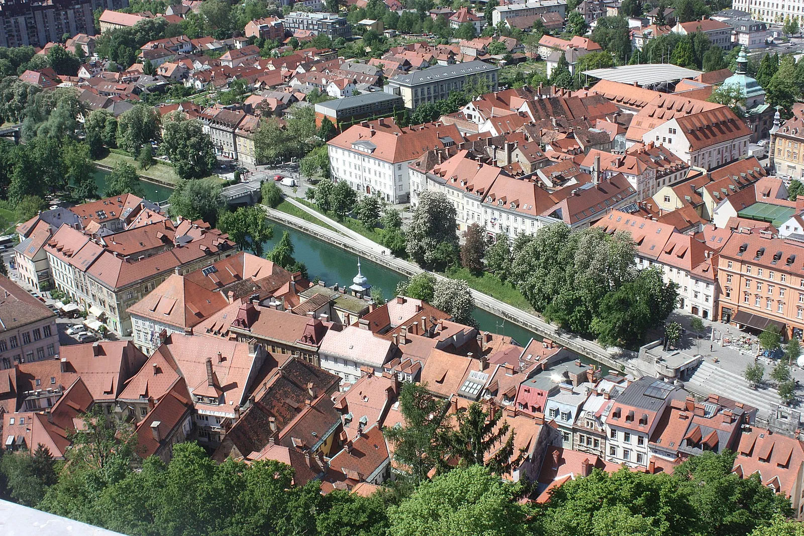 Red roofs of Ljubljana's old town divided by the green Ljubljanica River, seen from Castle Hill