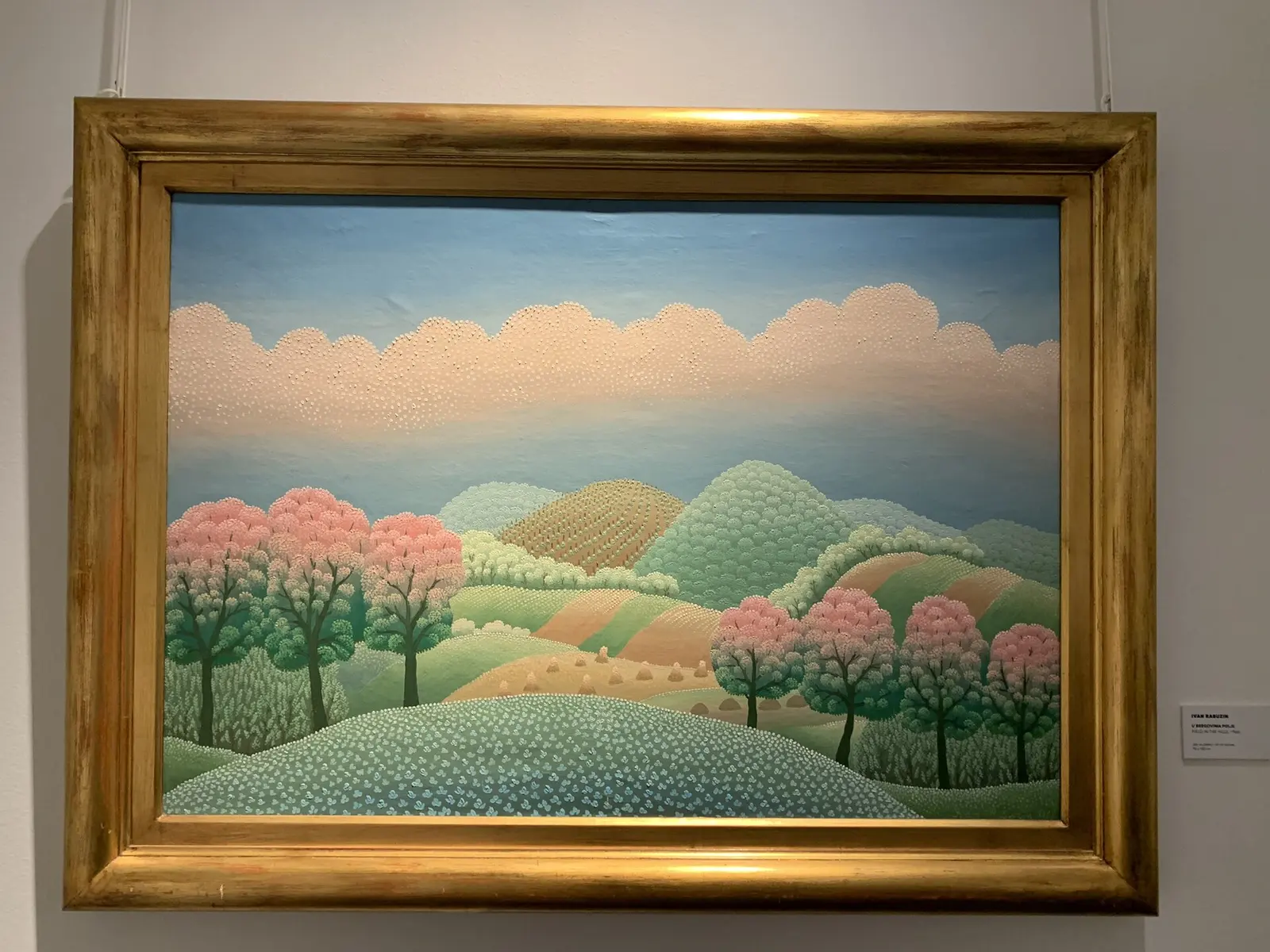 Rounded hills and flowering trees in Croatian naive landscape painting