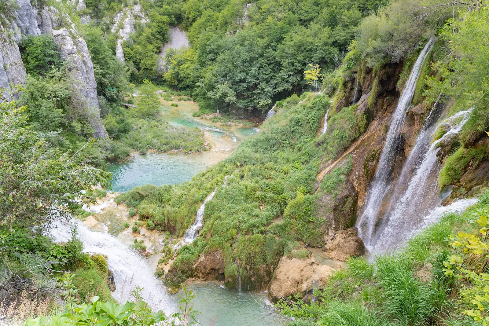 Waterfalls descending through green tufa terraces in the Lower Lakes at Plitvice