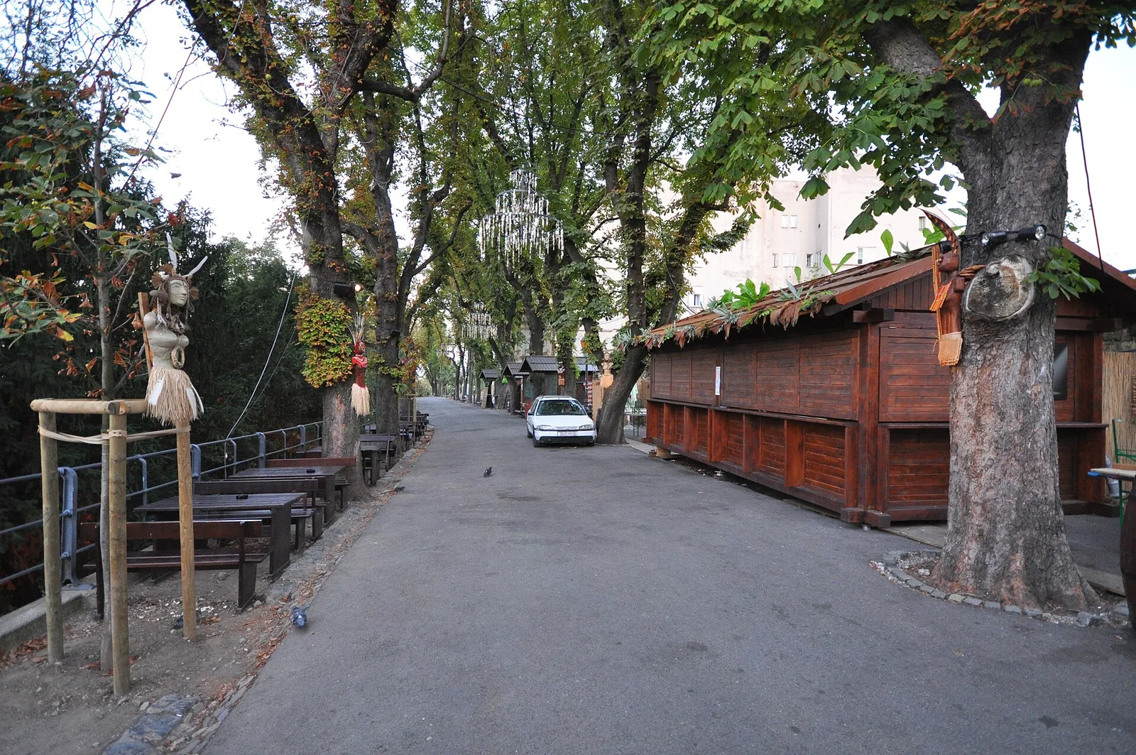 Tree-lined path and closed wooden event stalls along Strossmayer Promenade