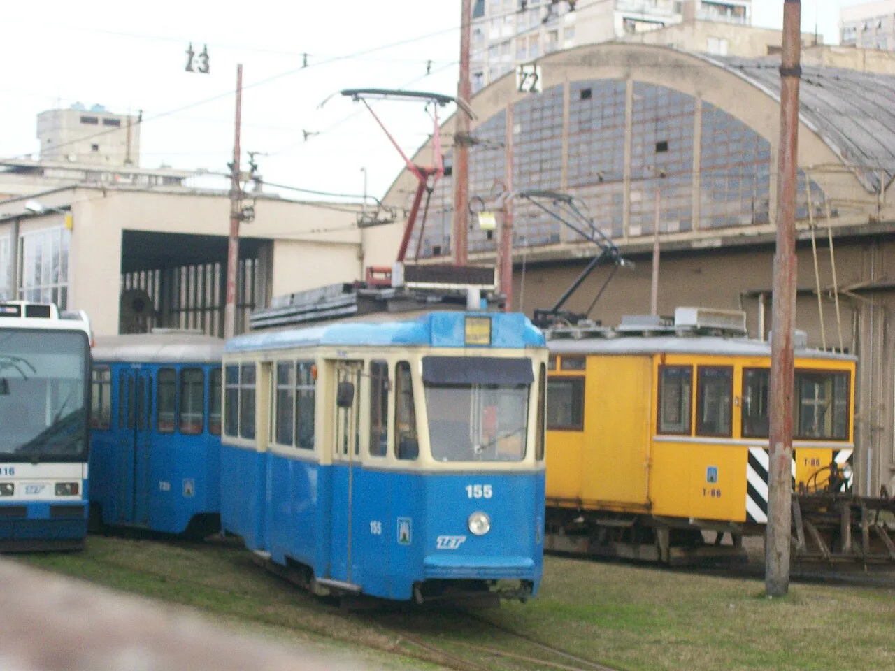 Blue and yellow Zagreb trams outside the Trešnjevka tram depot