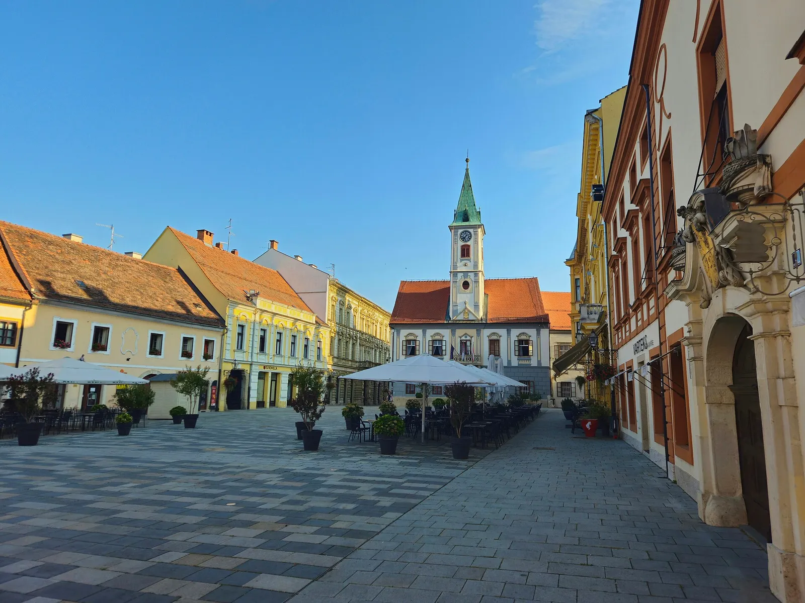 Café terraces, colourful façades and a church tower along Varaždin Korzo