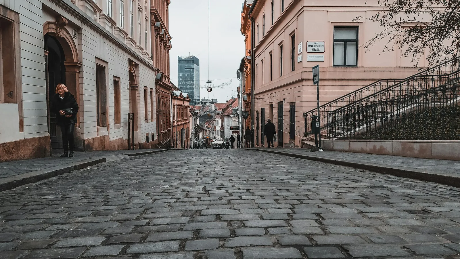 A steep cobbled lane between historic buildings in Zagreb