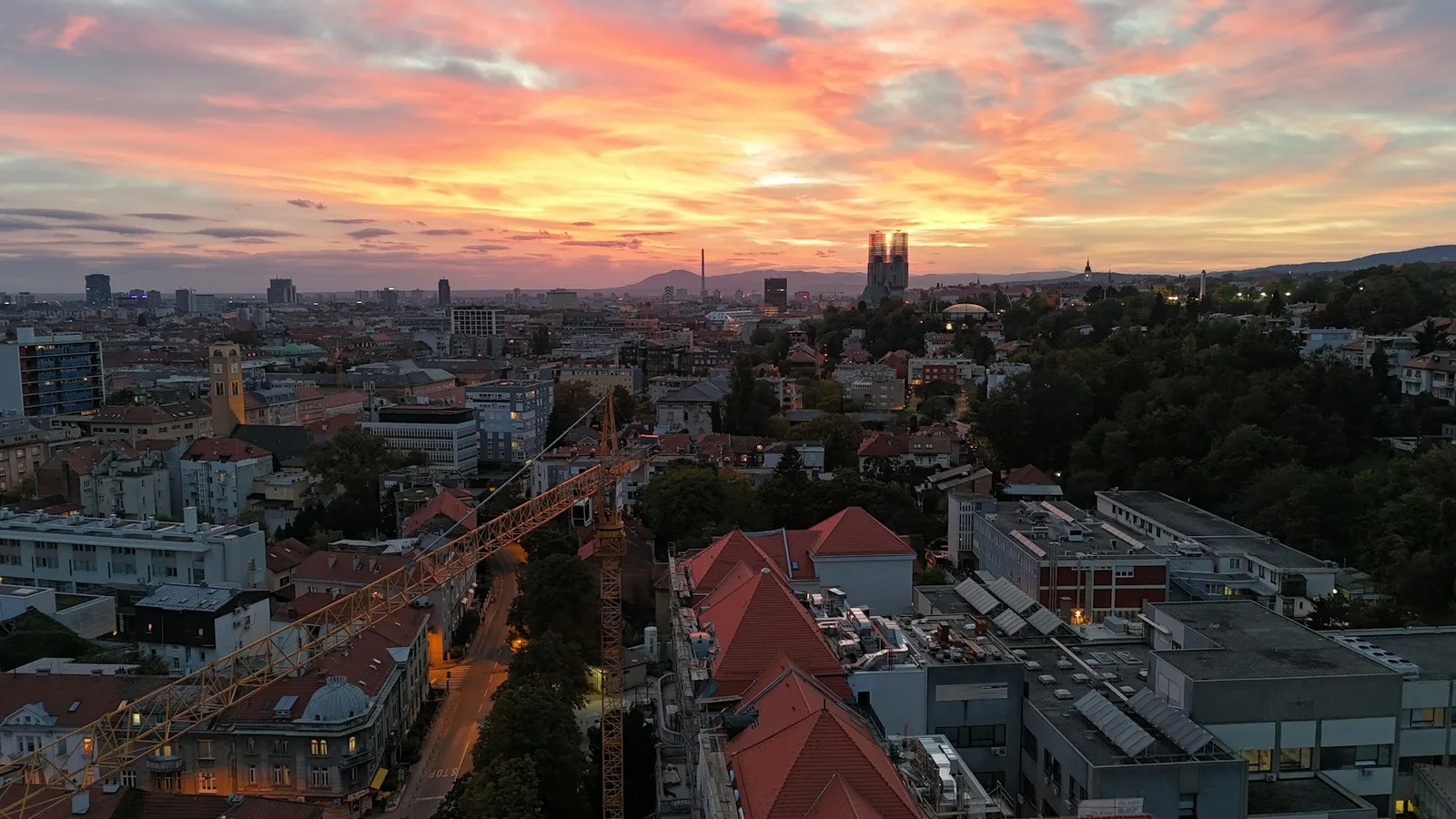 Zagreb’s cathedral towers and rooftops under a vivid sunset sky